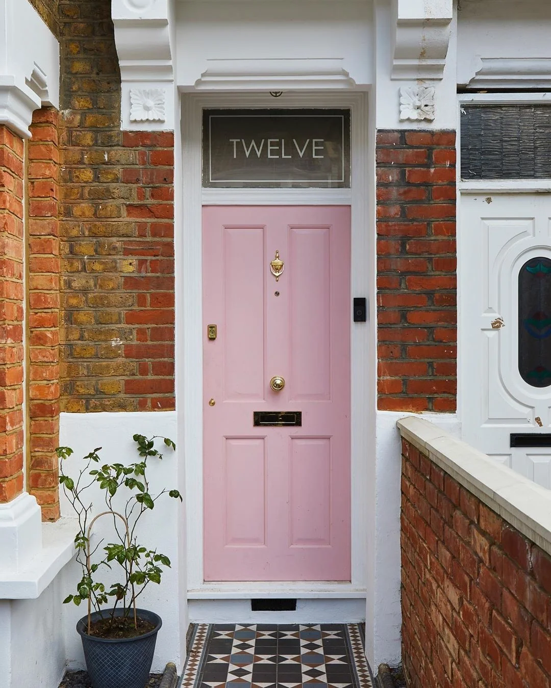 8 Simple DIY Home Projects For Beginners - Charming pink front door with gold hardware and classic architectural details.