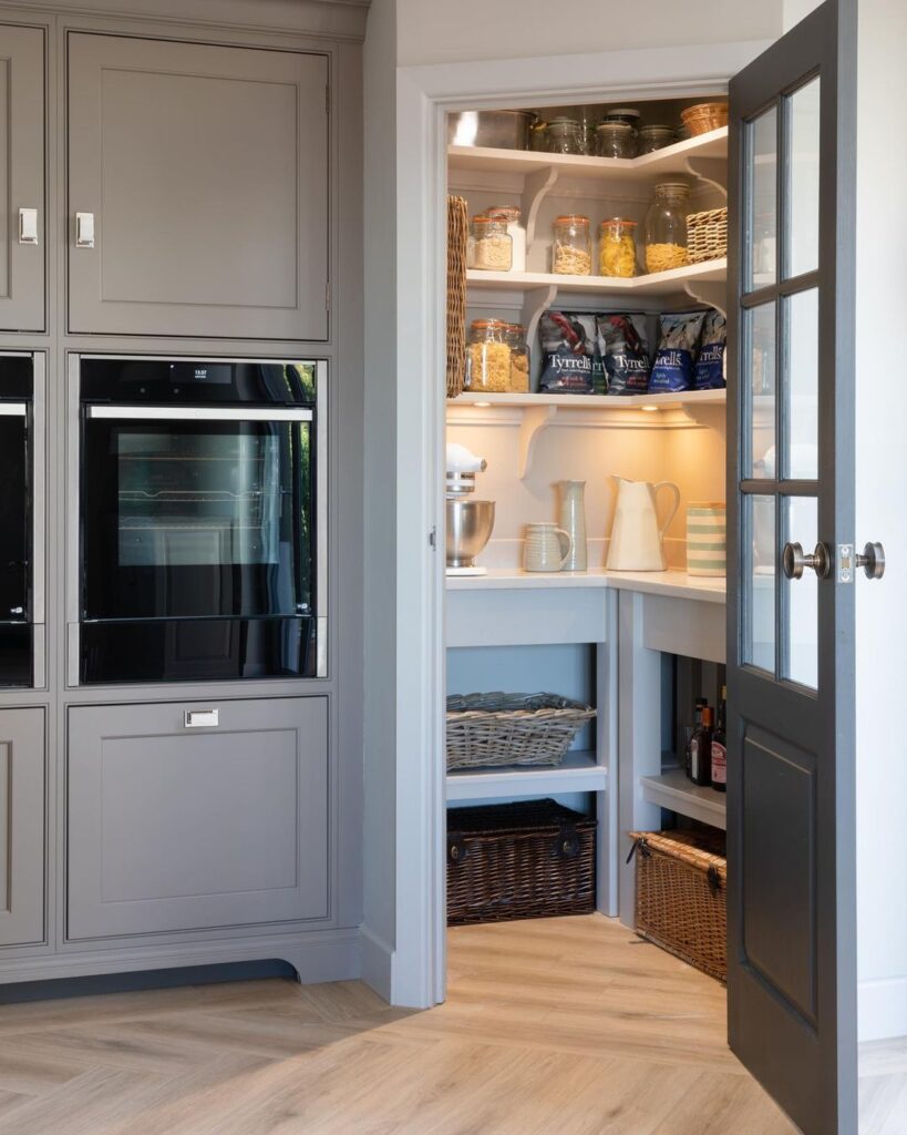 How A Kitchen Pantry Will Change Your Life - Organized kitchen pantry with built-in shelves, glass door, and neatly arranged jars, baskets, and kitchen essentials for efficient storage